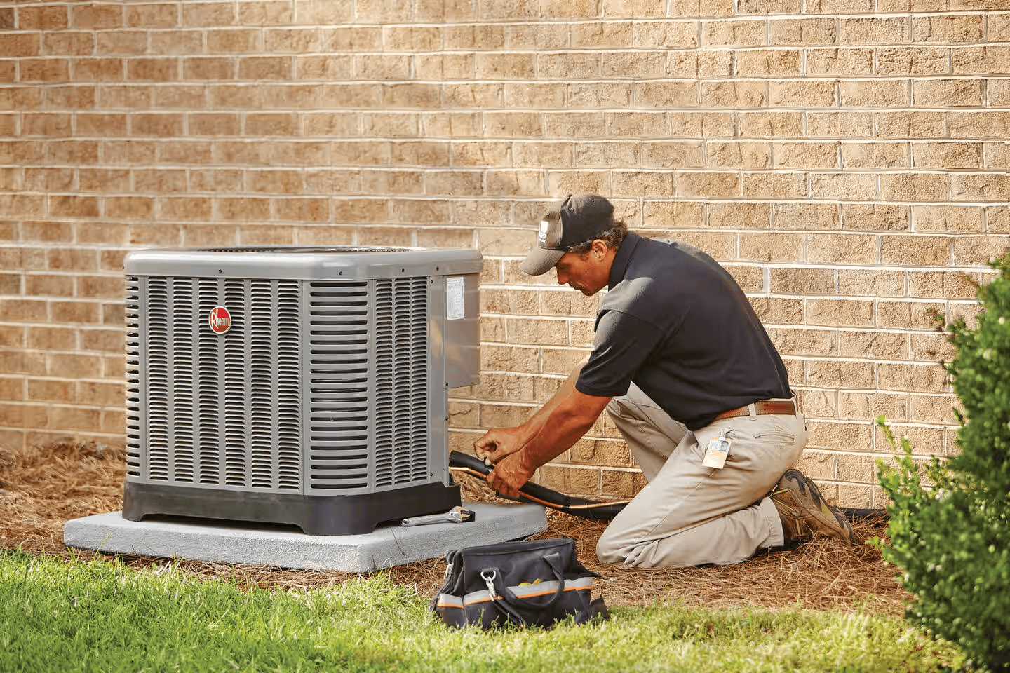 Technician performing AC repair and maintenance on outdoor air conditioning unit