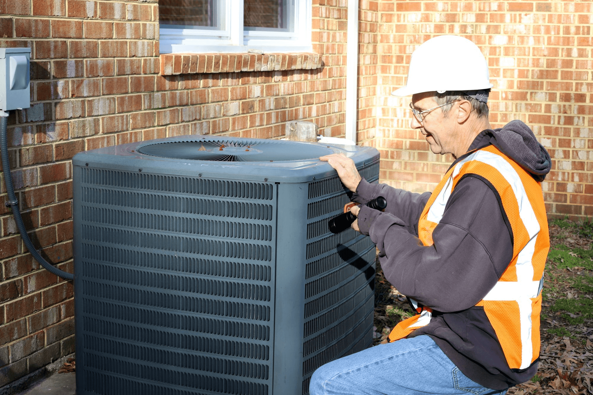 Air conditioning repair technician inspecting residential HVAC system
